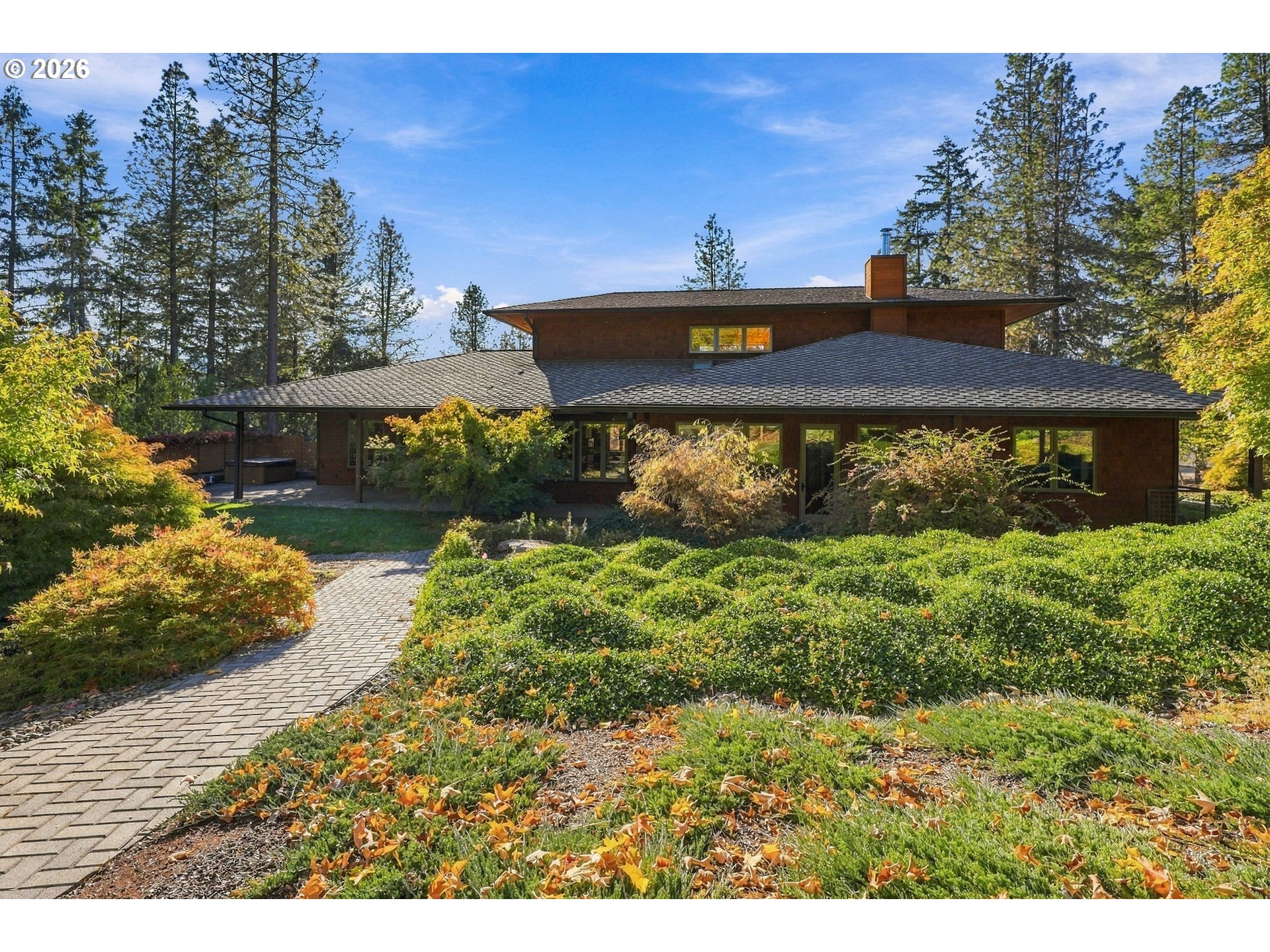 Mid-Century Modern home with a long low roofline, stone pathway and landscaped gardens at 509 Jasmine Way in Roseburg