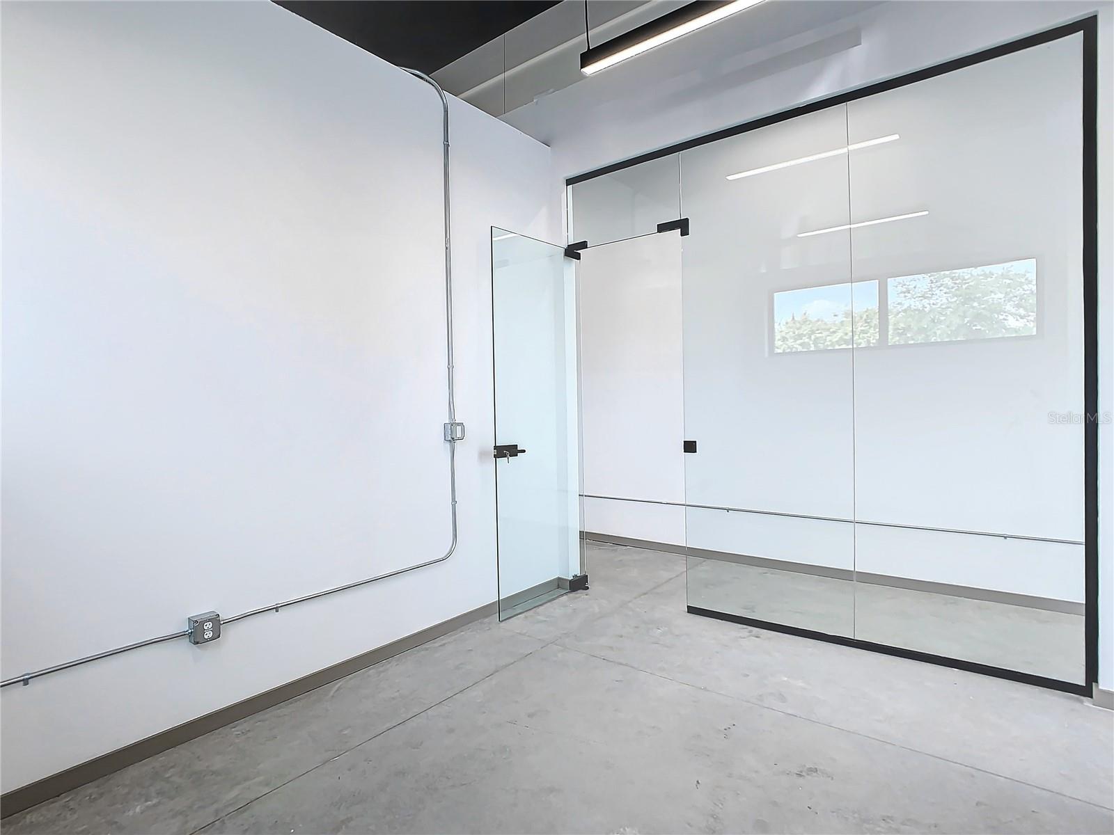 Sunset rendering of 12324 W Colonial Drive in Winter Garden, FL — modern minimalist single-story spec office building with white stucco facade, wood-slat cladding, recessed glass storefronts, and warm architectural uplighting