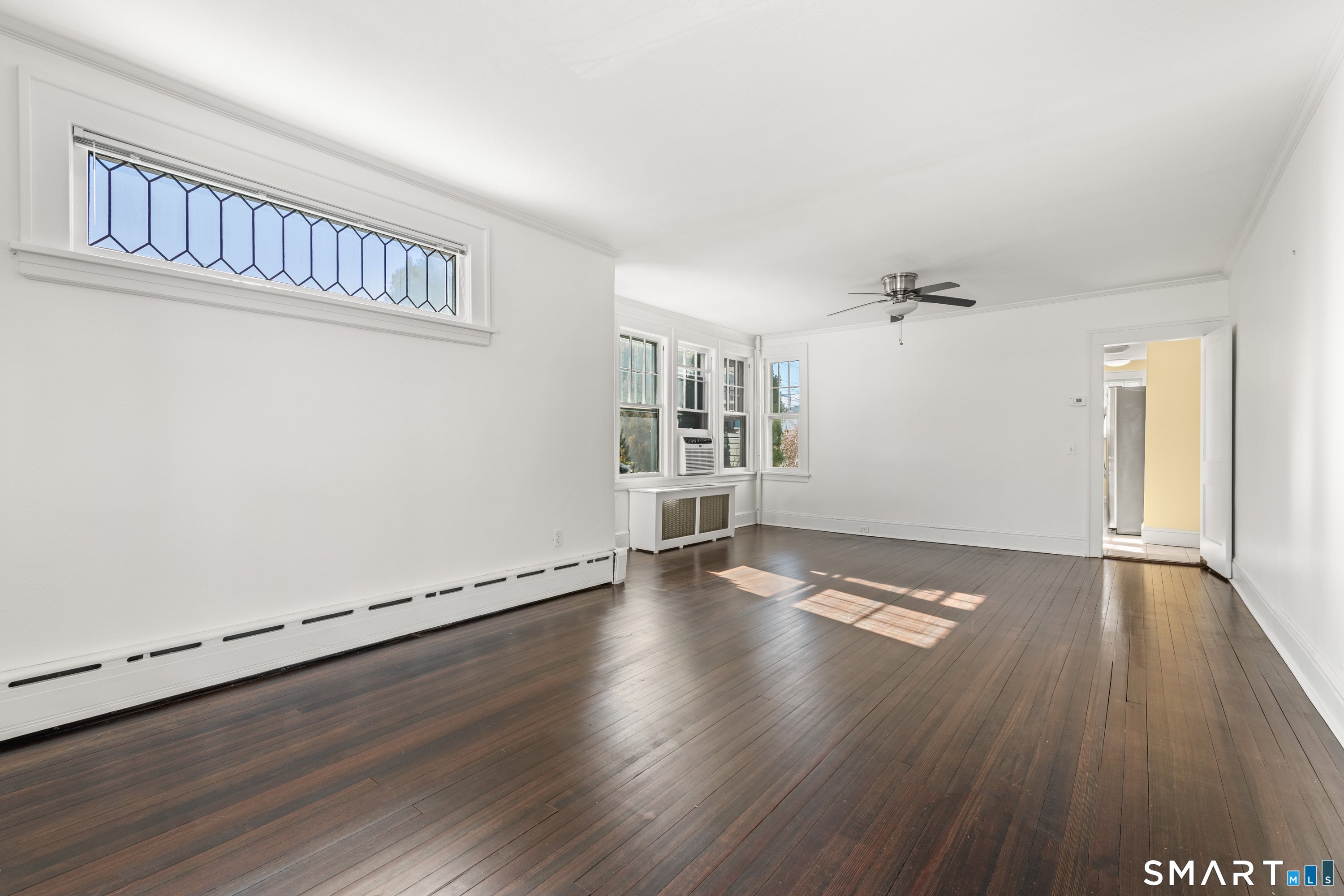 Living room with hardwood floors and stained glass transom