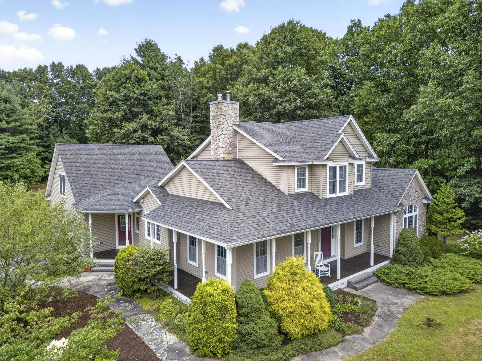 Aerial view of the home surrounded by mature woods on its 10 acre lot